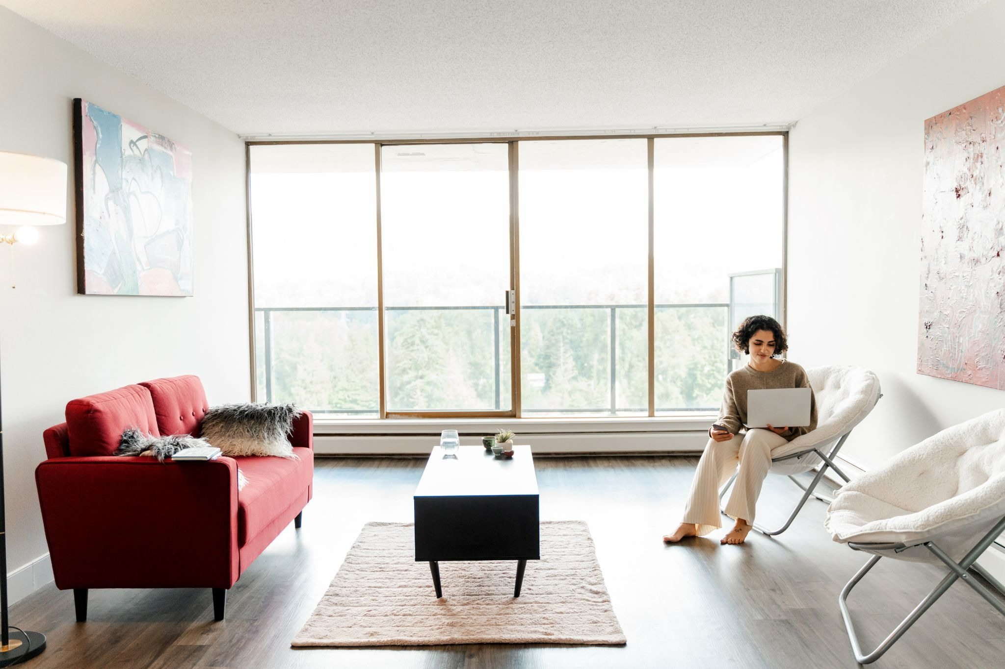 A woman is deliberating on choosing a tenant in the living room of her apartment.